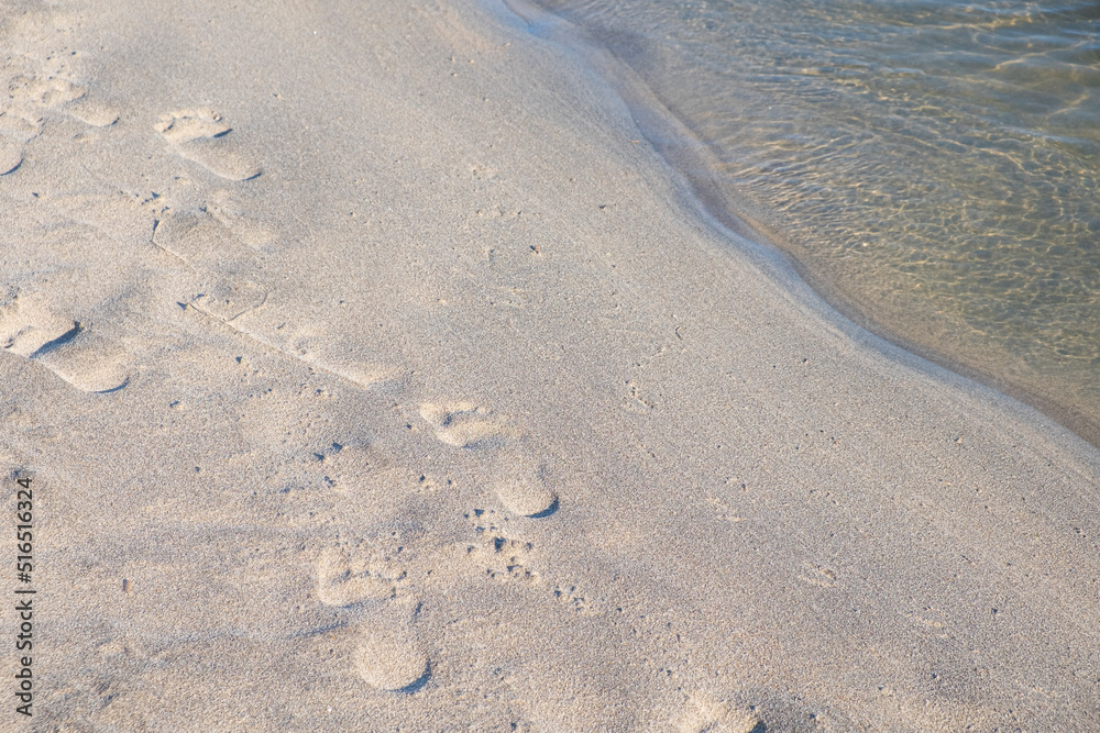 close up of footprints on sandy beach