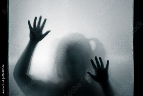 фотографія Shadowy figure, child behind glass - horror background