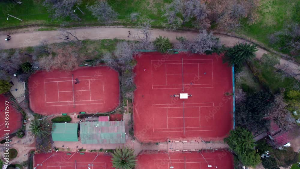 Static aerial overhead view of red clay tennis courts with people playing a match, O'Higgins Park, Santiago, Chile Static aerial overhead view of red clay tennis courts with people playing a match, O'Higgins Park, Santiago, Chile