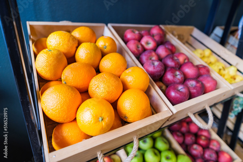 Healthy fruit and vegetables in grocery shop. Close up of basket with oranges in supermarket.