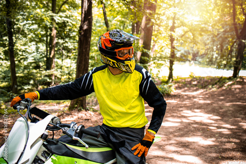 Fotografiet Portrait of professional dirt bike rider preparing for the motocross race through the forest