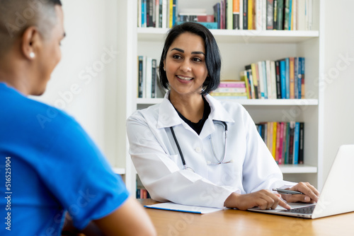Beautiful hispanic female doctor  talking with healthy patient