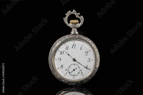 Silver mechanical antique pocket watch on black isolated background. Retro pocketwatch with second, minute and hour hand. Old round clock with dial for gentleman. Vintage timepiece. Symbol of time.