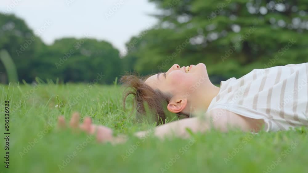 疲れて草原の上で休む女性