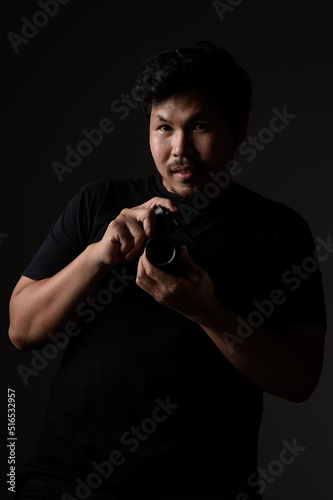 Asian man with Camera on black background.