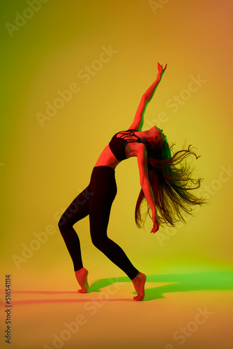 Wall Mural modern adult dancer poses in front of the studio izolated in neon light(red and green)