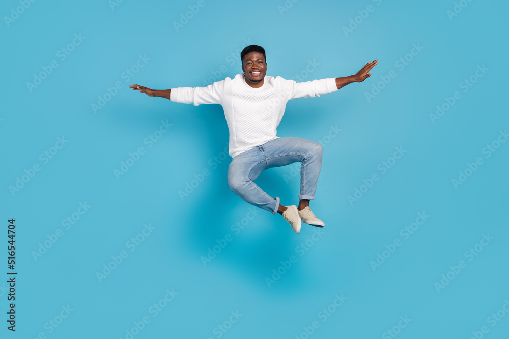 Full length portrait of satisfied cheerful person arms flight toothy smile rejoice isolated on blue color background