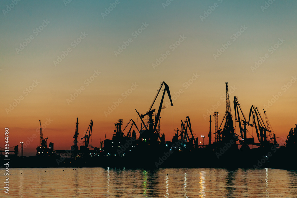 Sunset behind the silhouette of the port Sunset behind the silhouette of the port