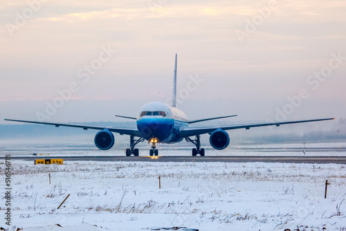 Aircraft landing on the runway of an airfield in witner photo