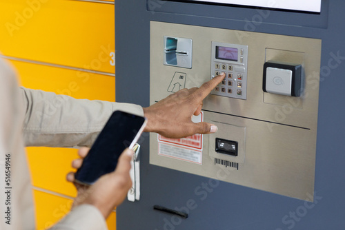 Man client using automated self service post terminal machine or locker. Mail shipping concept photo