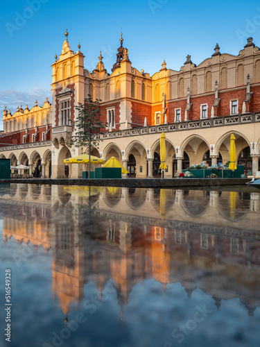 Reflections of Cloth Hall Sukiennice building at sunrise on main square of Krakow city, Poland