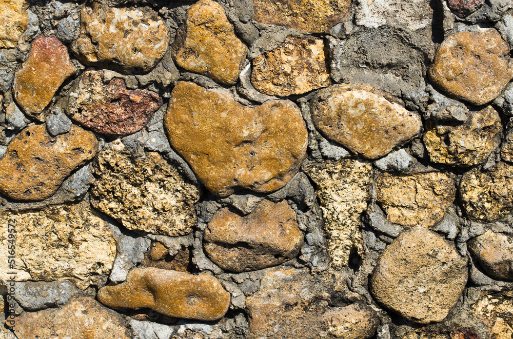 Texture of masonry with cobblestones and cement.