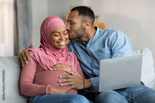 Romantic Islamic Spouses Awaiting Baby Relaxing With Laptop At Home