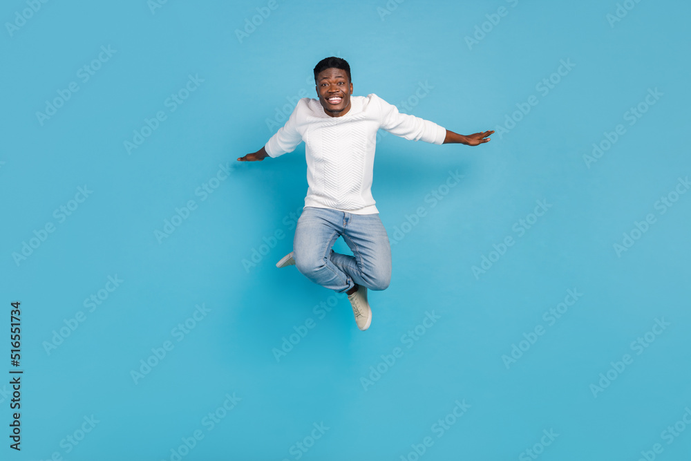 Full body photo of excited crazy man arms flight freedom good mood isolated on blue color background