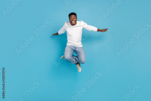 Full body photo of excited crazy man arms flight freedom good mood isolated on blue color background