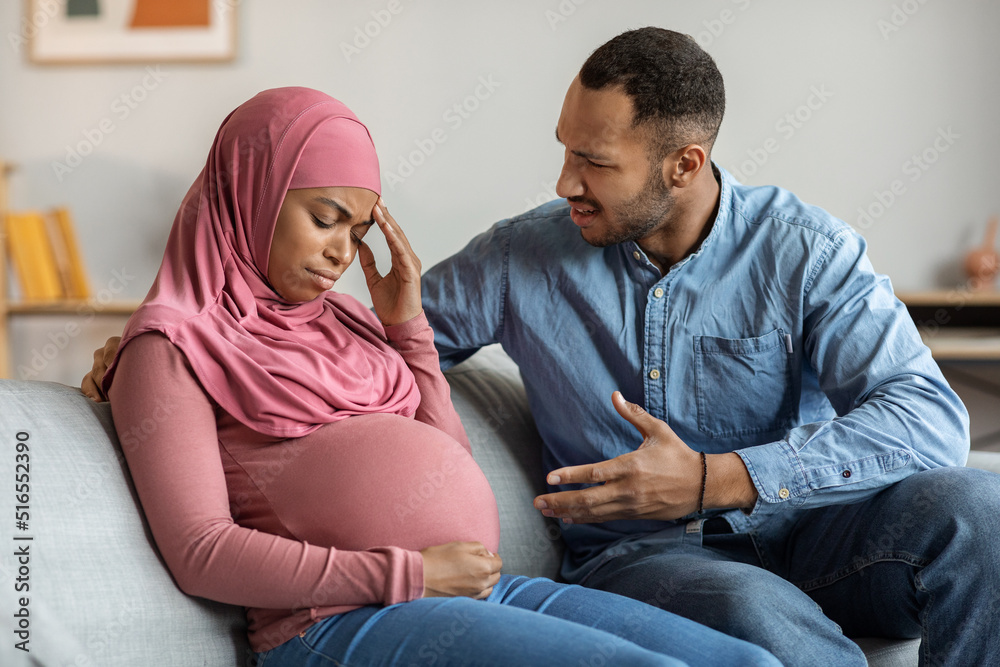 Psychological Abuse. Aggressive black man arguing with pregnant muslim wife at home