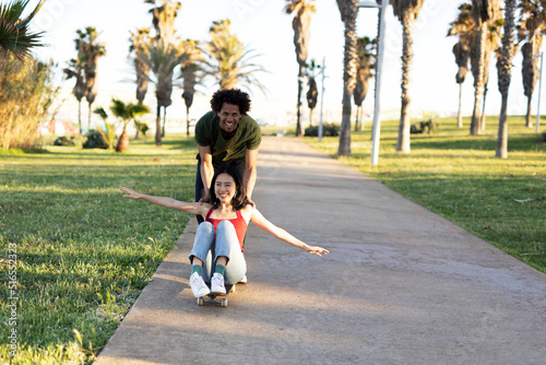 Boyfriend and girlfriend enjoy outside. Happy couple with skateboard having fun © JustLife