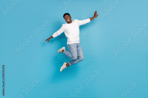 Full size photo of overjoyed person enjoy freedom jumping isolated on blue color background