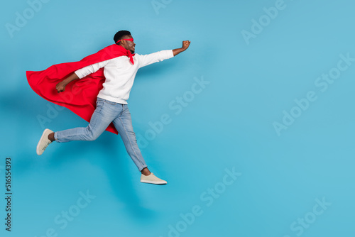 Full body profile photo of strong guy raise hand fly empty space isolated on blue color background © deagreez