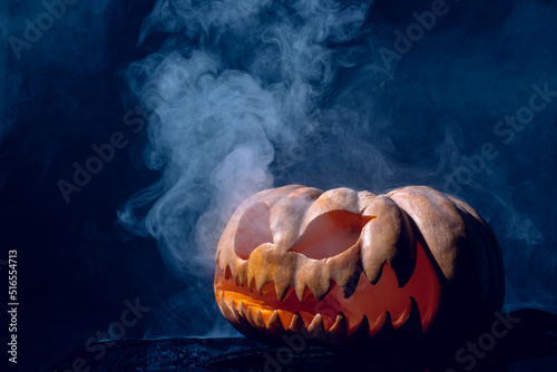 Composition of halloween carved pumpkin with smoke on black background
