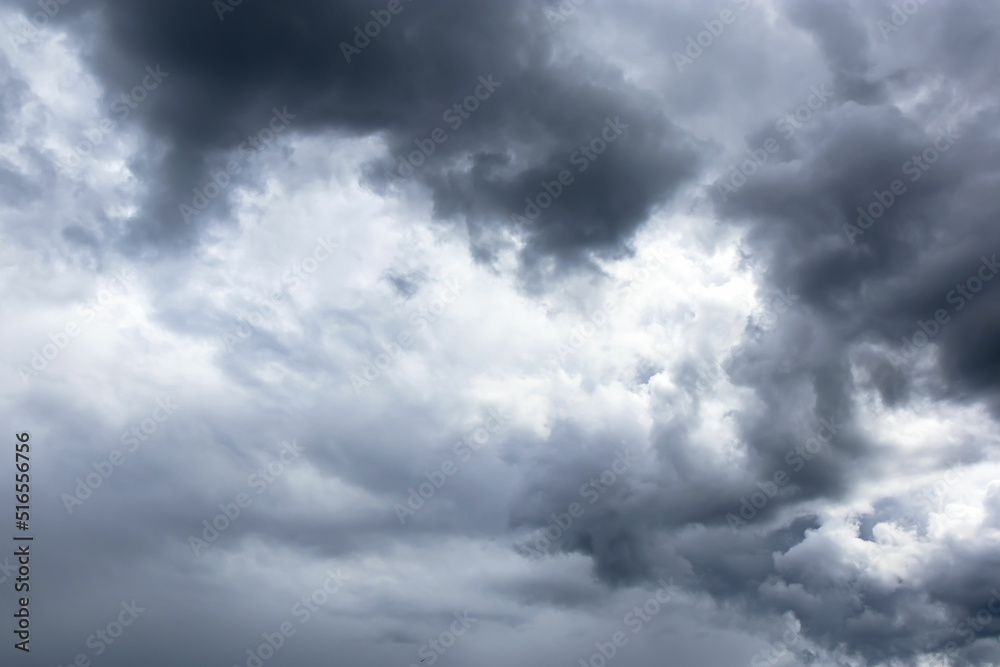Dark and dramatic storm clouds. Sun light behind storm clouds. Dark and dramatic storm clouds. Sun light behind storm clouds.