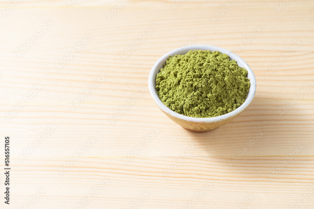 Henna powder in cup on space of pine wood background Henna powder in cup on space of pine wood background