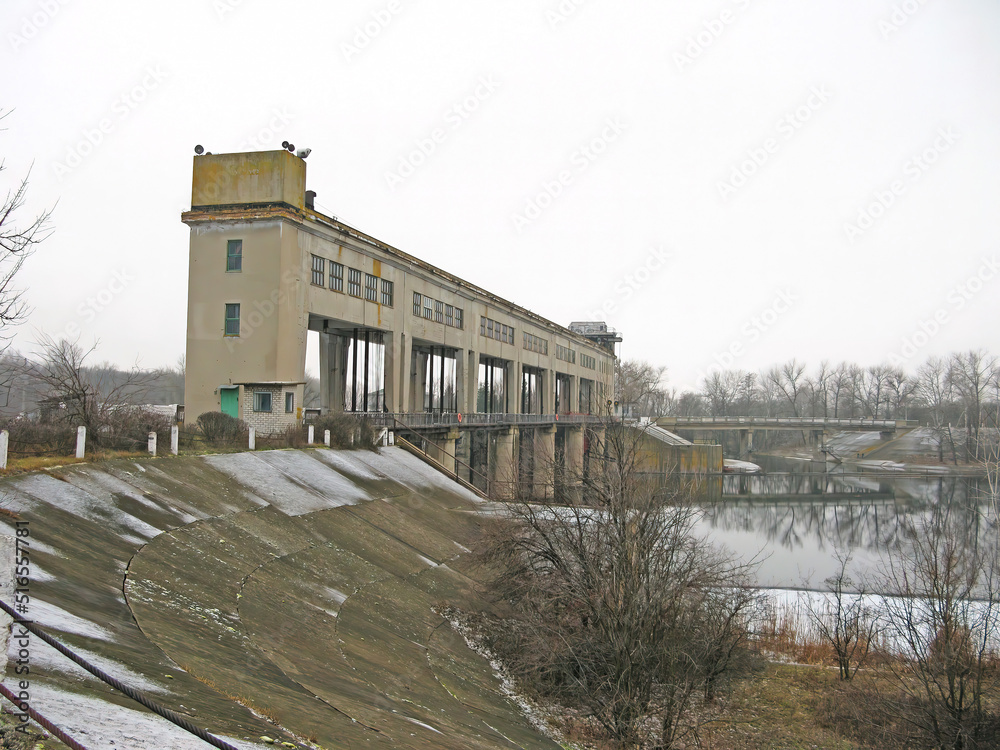 view of the hydroelectric dam, water discharge through locks, long exposure shooting. Hydropower dam in Ukraine. A dam on a winter river. Dam to release water on the river