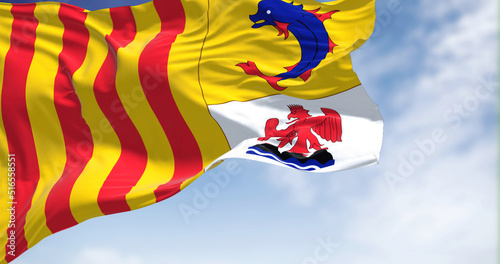 The region flag of Provence-Alpes-Côte d'Azur waving in the wind on a clear day.