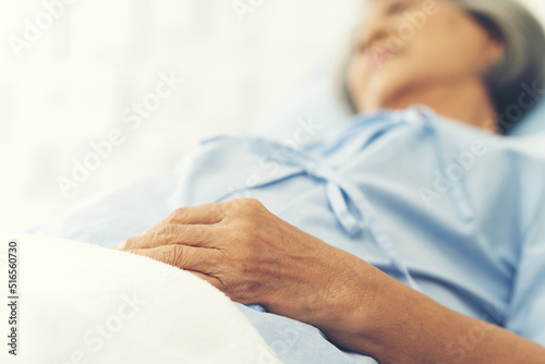 Old hands woman laying on bed at hospital ward. medicine, health care, old people and quarantine concept © amorn