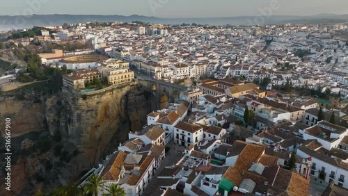 Flying over houses and Puente Nuevo bridge in Ronda, Andalusia. Great aerial morning view of Ronda, Spain with fog