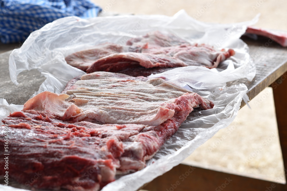 argentinean man salting meat for the barbecue