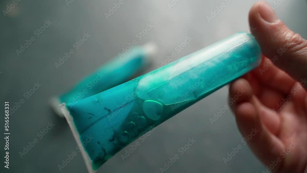 Large transparent plastic tube with blue dye close-up. Blue pigment for artists Large transparent plastic tube with blue dye close-up. Blue pigment for artists