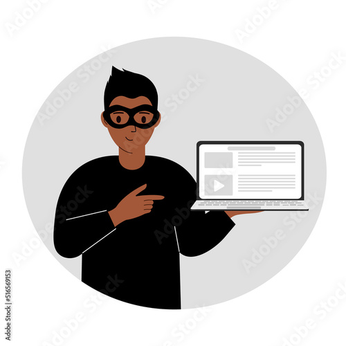 Hacker in a black mask with a computer. The cybercriminal is holding a laptop. Cyber attack, mobile phishing, scam.
