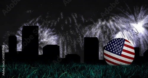 Animation of fireworks and cityscape over ball with usa flag photo