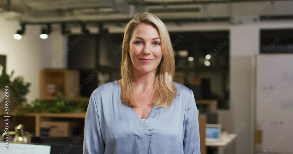 Video of happy caucasian woman looking at camera in office