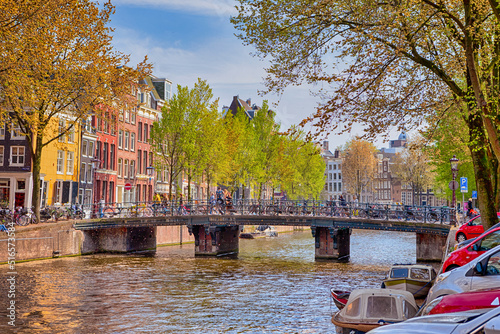 Colorful Romantic Amsterdam River Canal For Transportation and Boat Cruises For Guests and Visitors Along Arched Bridges in Amsterdam. photo