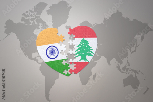 puzzle heart with the national flag of india and lebanon on a world map background.Concept. photo