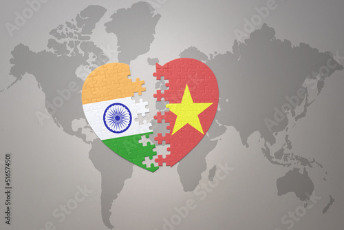 puzzle heart with the national flag of india and vietnam on a world map background.Concept.
