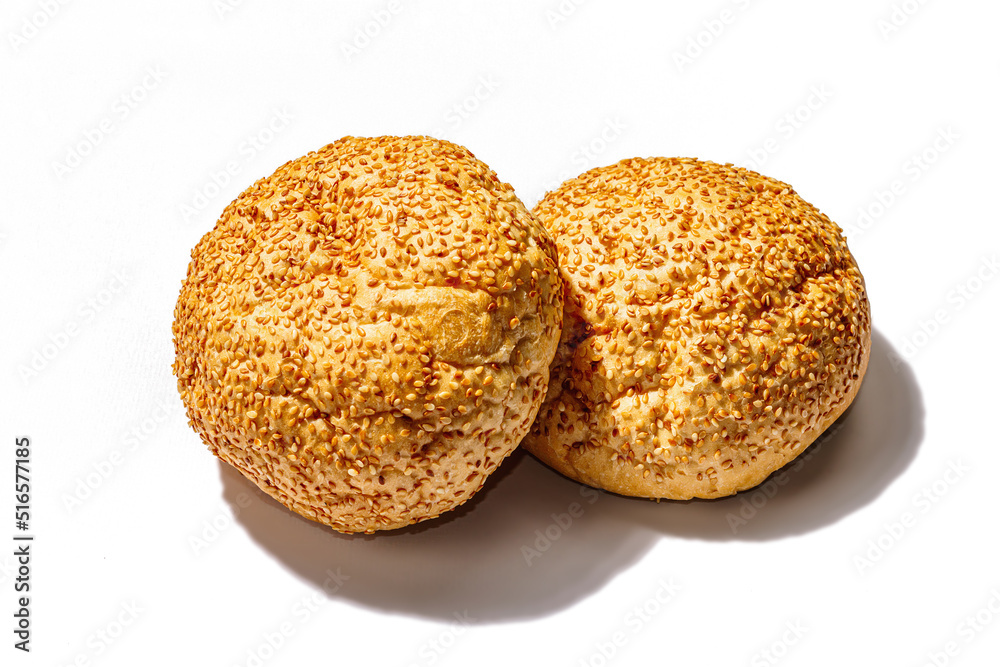 Fresh buns with sesame isolated on a white background. An indispensable ingredient for burgers Fresh buns with sesame isolated on a white background. An indispensable ingredient for burgers