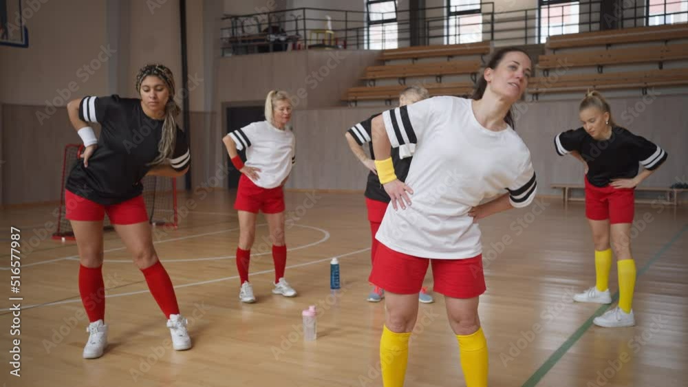 Group of young and old women, sports team players in gym, doing warming up exercise. Group of young and old women, sports team players in gym, doing warming up exercise.