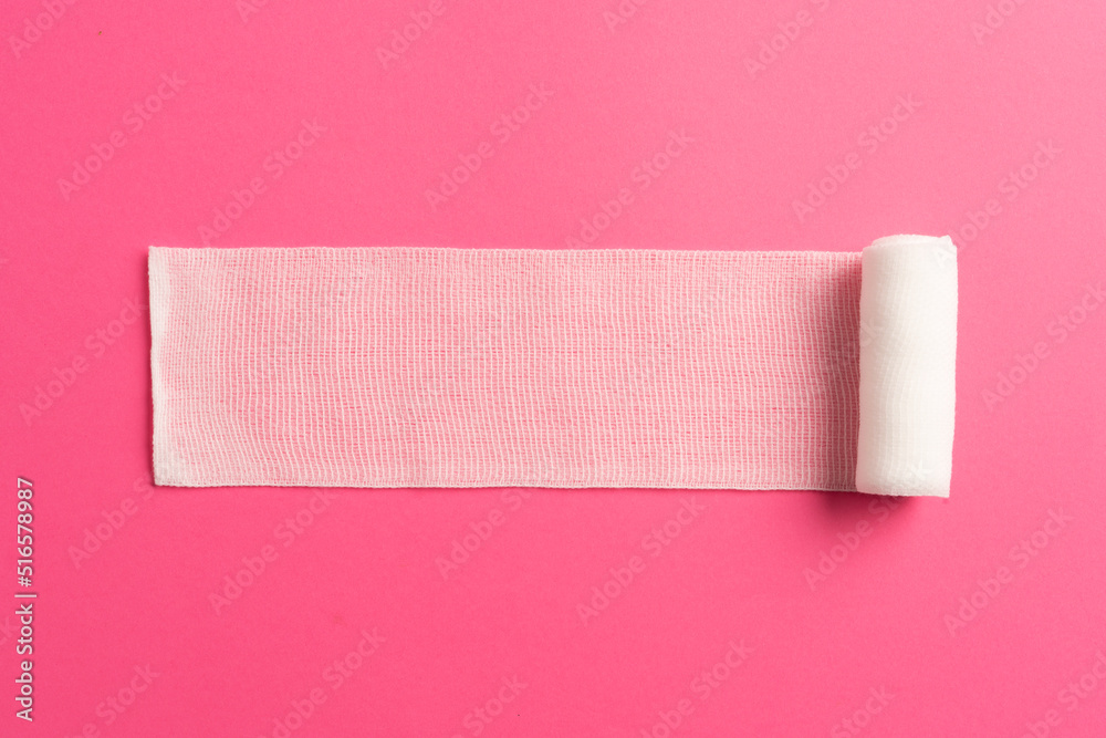 Obraz premium First aid, injury protecting wrapping and wound dressing concept clean cotton gauze bandage isolated on colorful background with space for sign.