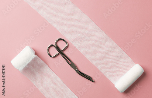 Medical bandages with scissors on the colorful background. First aid kit, medical content.