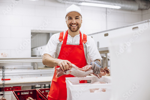 Man butcher at the freezer cutting meat