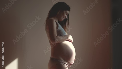 pregnant woman. health pregnancy motherhood procreation concept. close-up belly of a pregnant woman. woman waiting for a newborn baby. pregnant woman holding her belly sun indoors