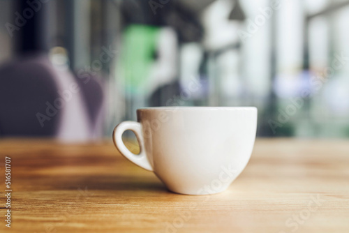 Coffee cup on wooden table in cafe restaurant with blurred background