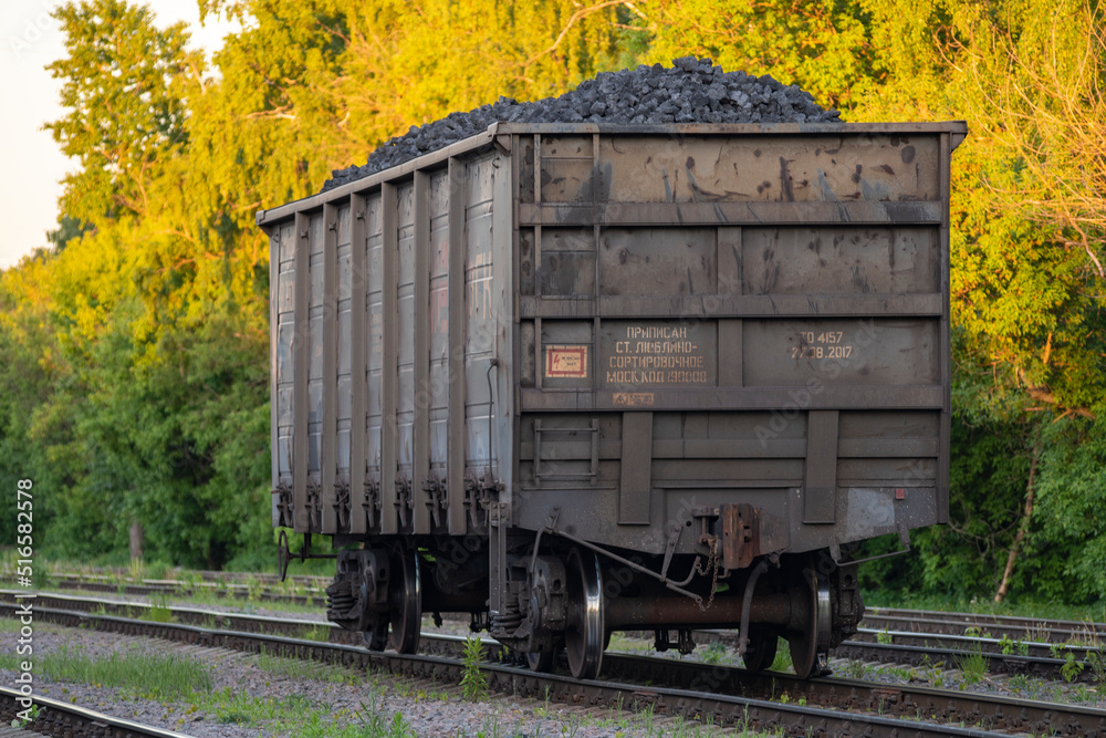 RU, Moscow 07.06.2022: Separately standing on the railway tracks one wagon with coal. Freight railway wagon separately from the train. RU, Moscow 07.06.2022: Separately standing on the railway tracks one wagon with coal. Freight railway wagon separately from the train.