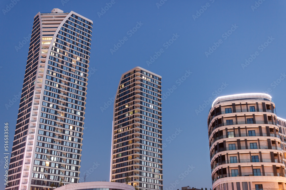 Naklejka premium Skyscrapers landscape at night. Real estate concept. Tall buildings with night lights.