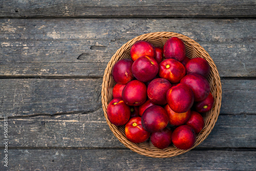 Tray of Fresh red nectarines. Wooden background. Top view Fresh organic ripe  wood table background woven basket fruit