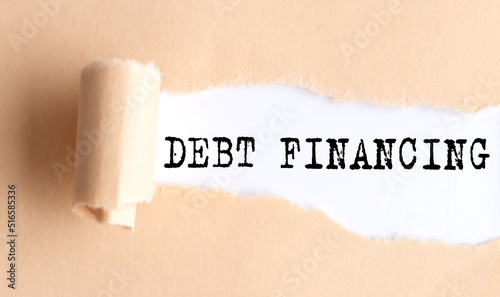 The text DEBT FINANCING appears on torn paper on white background.