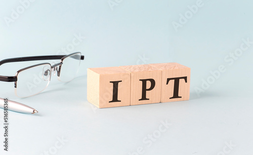 Text IPT - Item Per Transaction - written on the wooden cubes on blue background photo